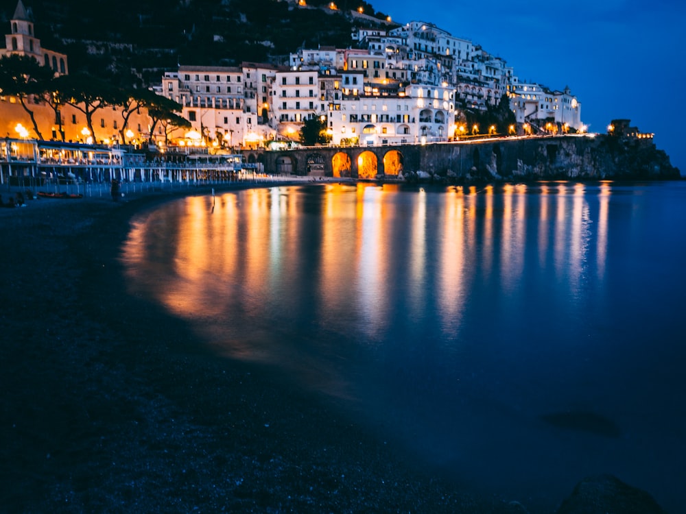 white buildings beside sea during nighttime