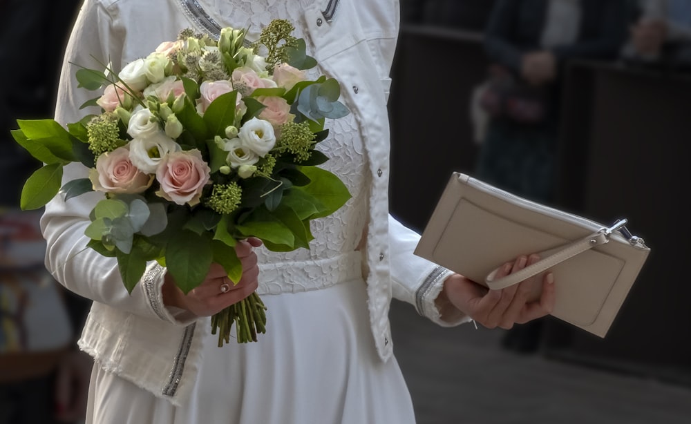 woman holding pink-and-white rose flower arrangement