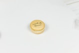 A single macaron on a light, plain background with 'maid of honor' written on top in cursive.