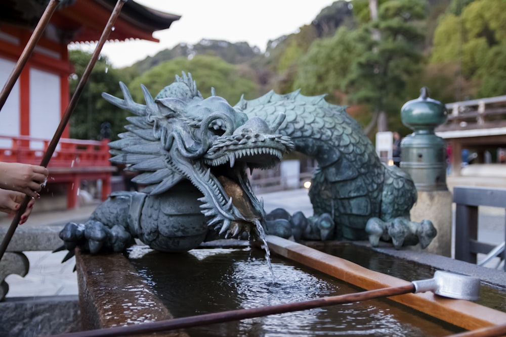 selective focus photography of blue dragon mini water fountain
