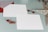 Two blank white cards are placed on a light blue background. Beside them is a red envelope with a striped flap. Decorative red gems and a sparkling silver star-shaped ornament are arranged around the cards, giving a festive appearance.