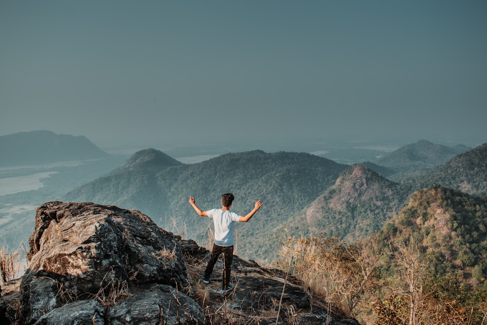 man standing on mountain cliff