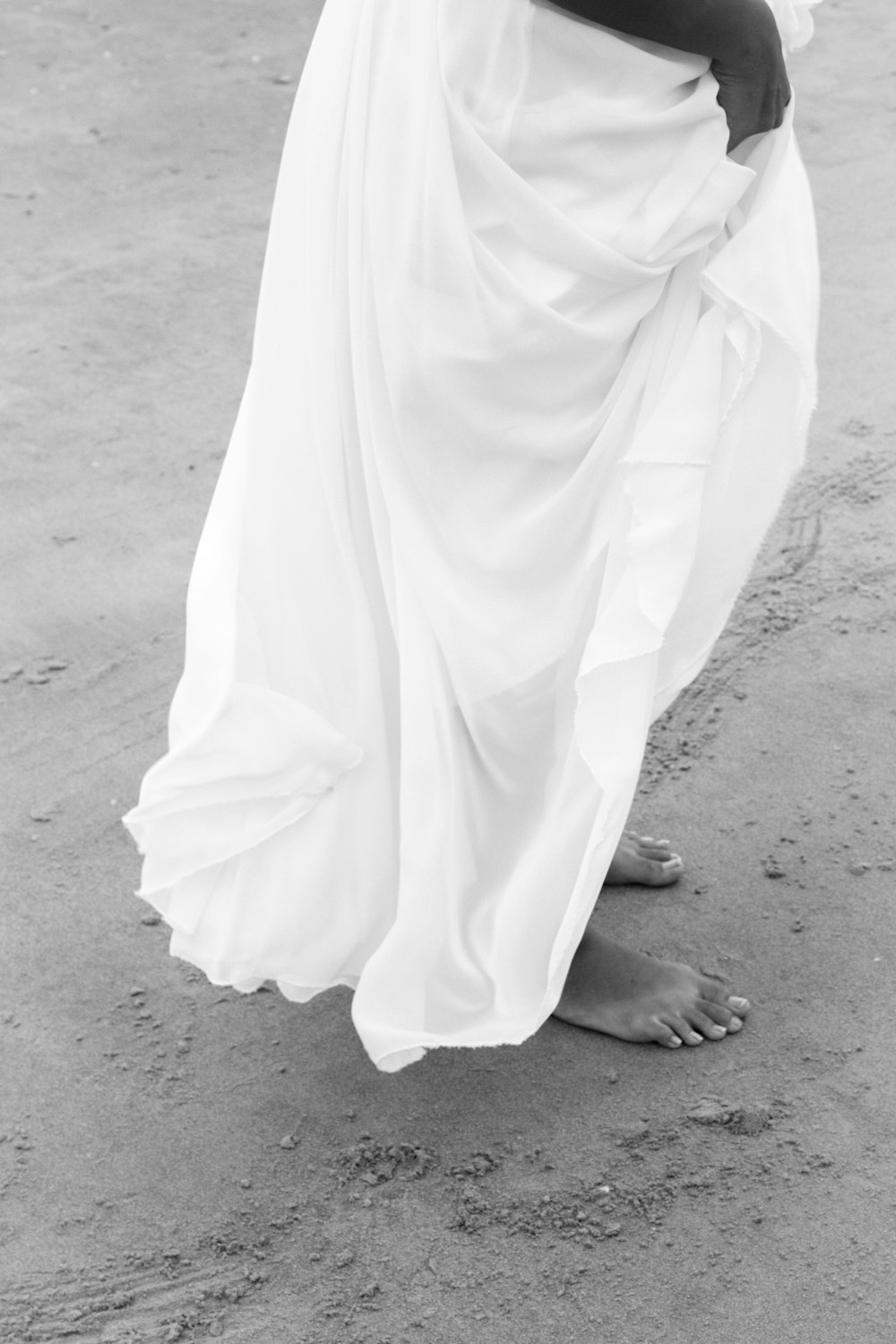 barefooted woman in long skirt during daytime greyscale photography