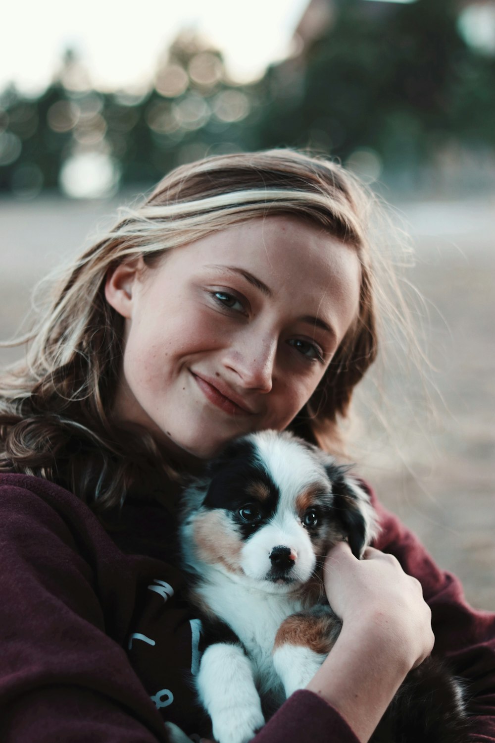 mujer sonriente abrazando cachorro