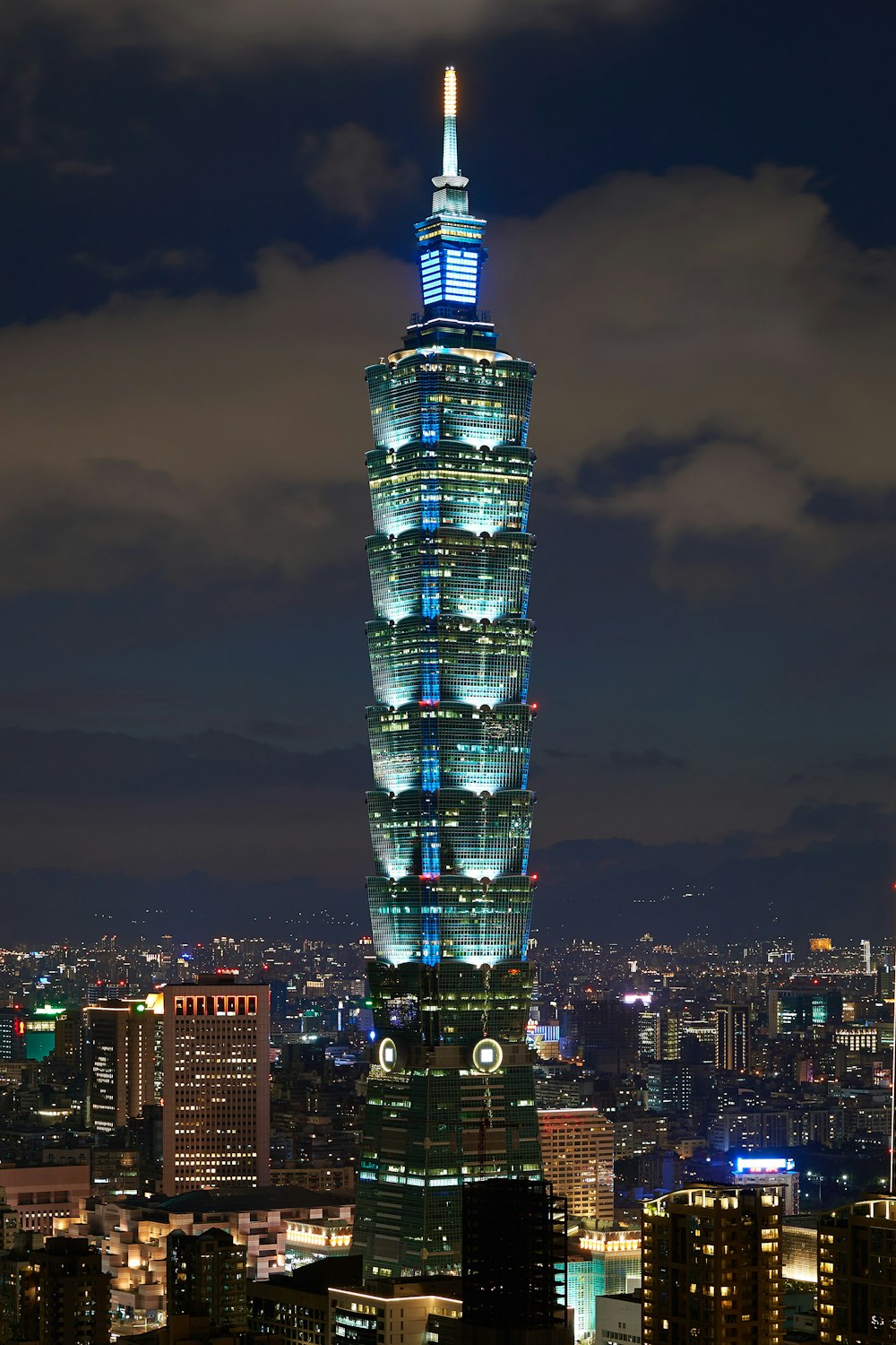 blue high-rise tower under gray sky