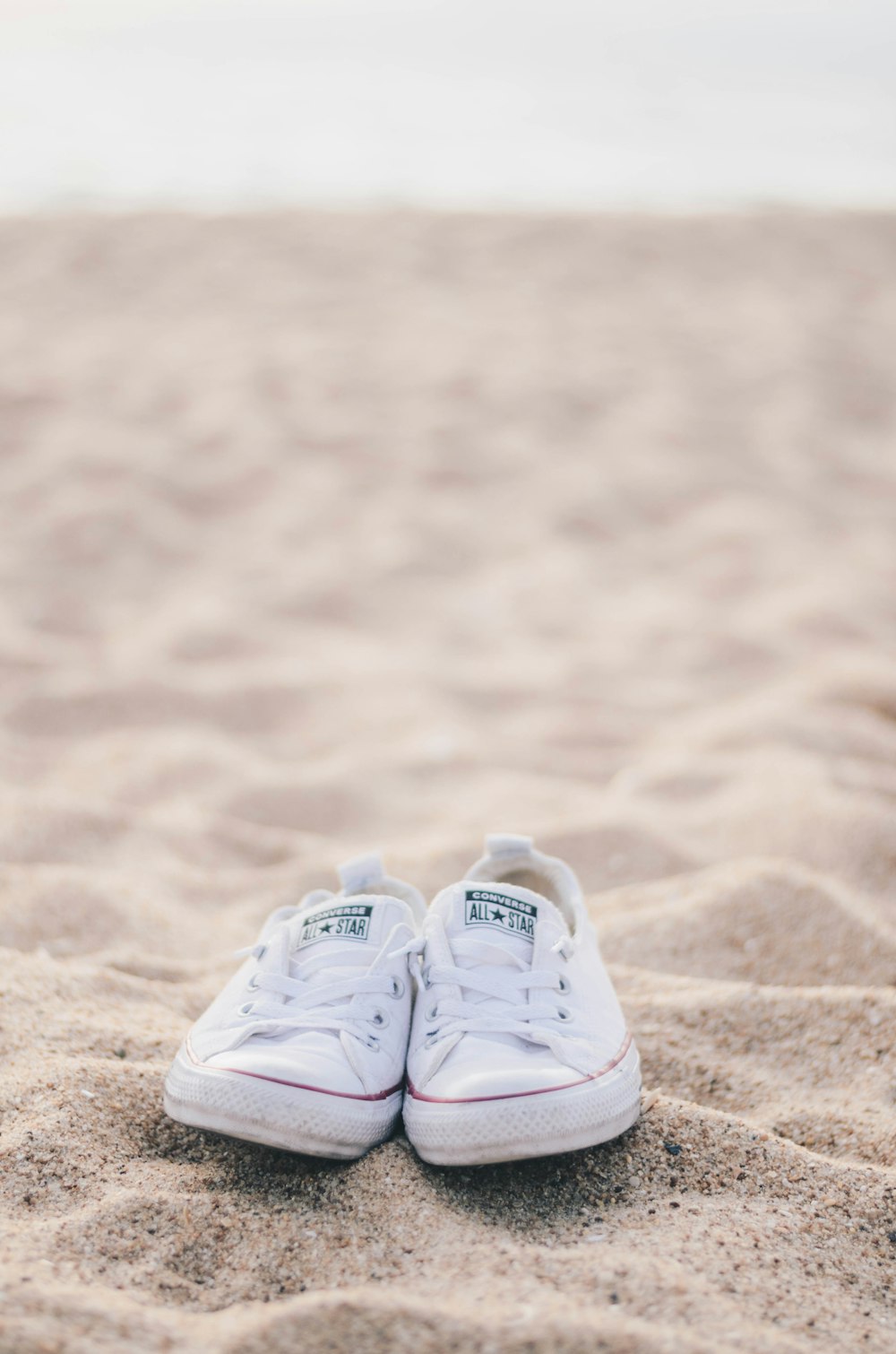 pair of white Converse low top sneakers