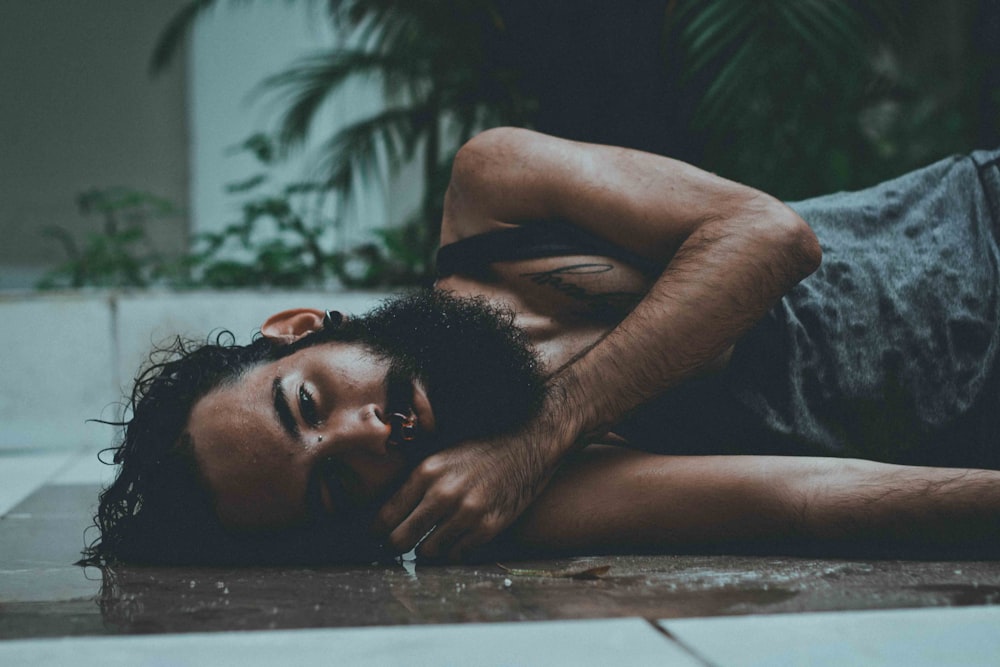 man laying on floor near tree