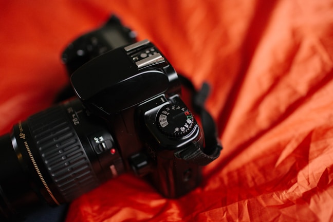 A close-up of a modern digital camera on a table.
