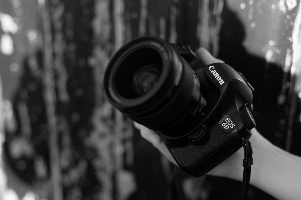 a black and white photo of a person holding a camera