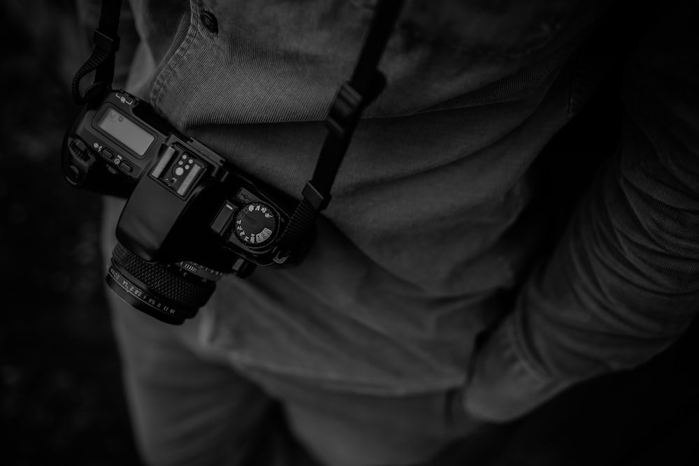 person in dress shirt with black DSLR camera greyscale photography