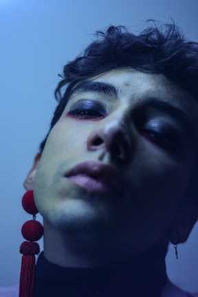 Close-up of a model's face highlighting bold makeup and statement earrings, embodying dopeamor's edgy vibe.