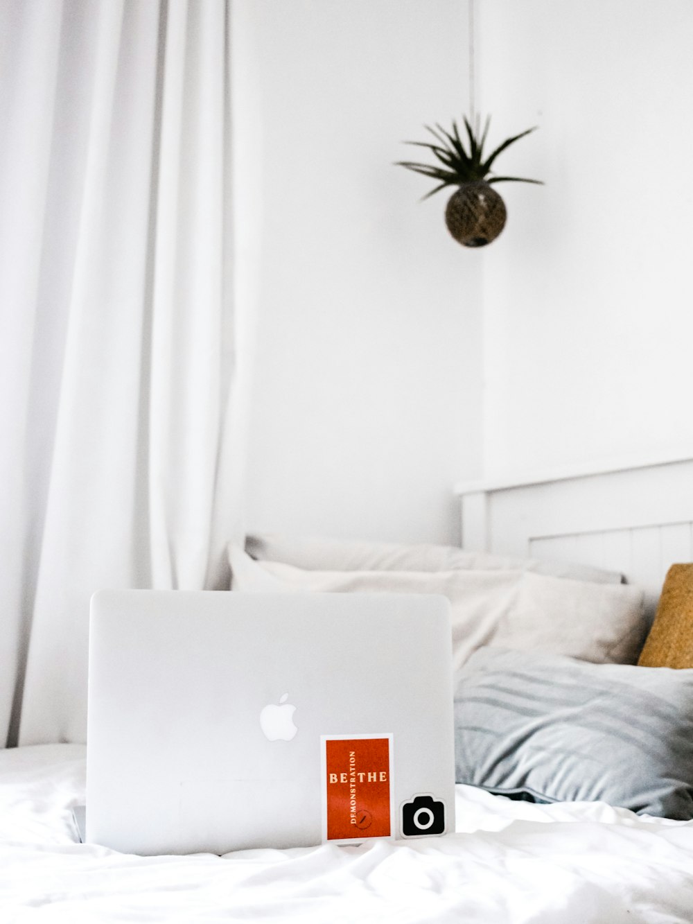 white MacBook on white comforter