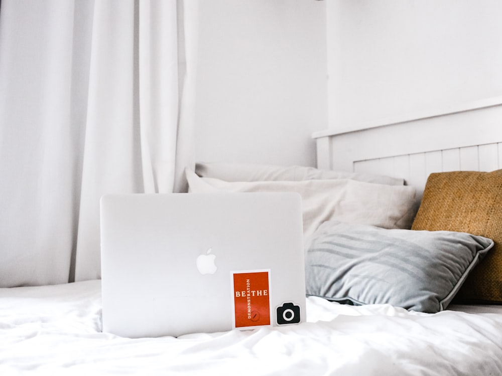 MacBook Air on white bed inside bedroom