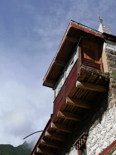 The exterior of a home showcasing distinct red sandalwood finishes under a bright sky.