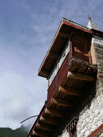 The exterior of a home showcasing distinct red sandalwood finishes under a bright sky.