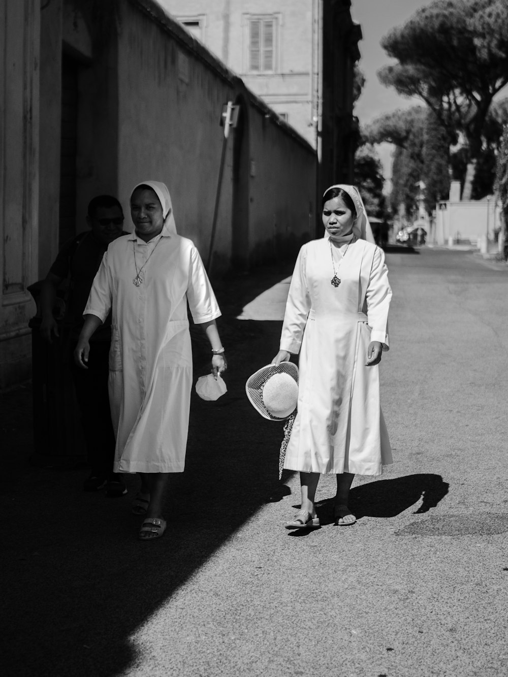 two nun walking beside house
