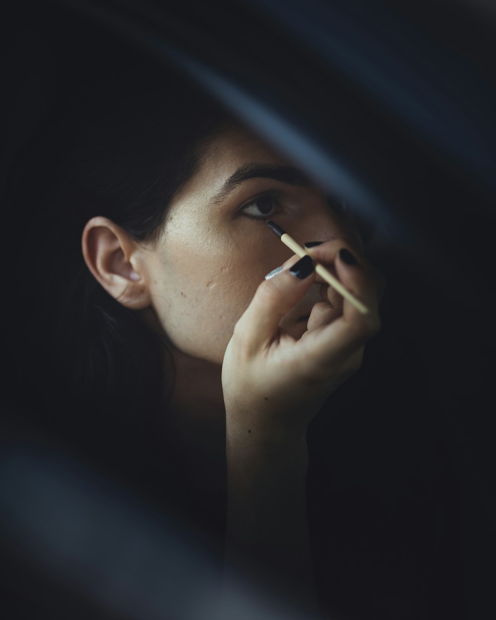 woman holding eyelashes on focus photography