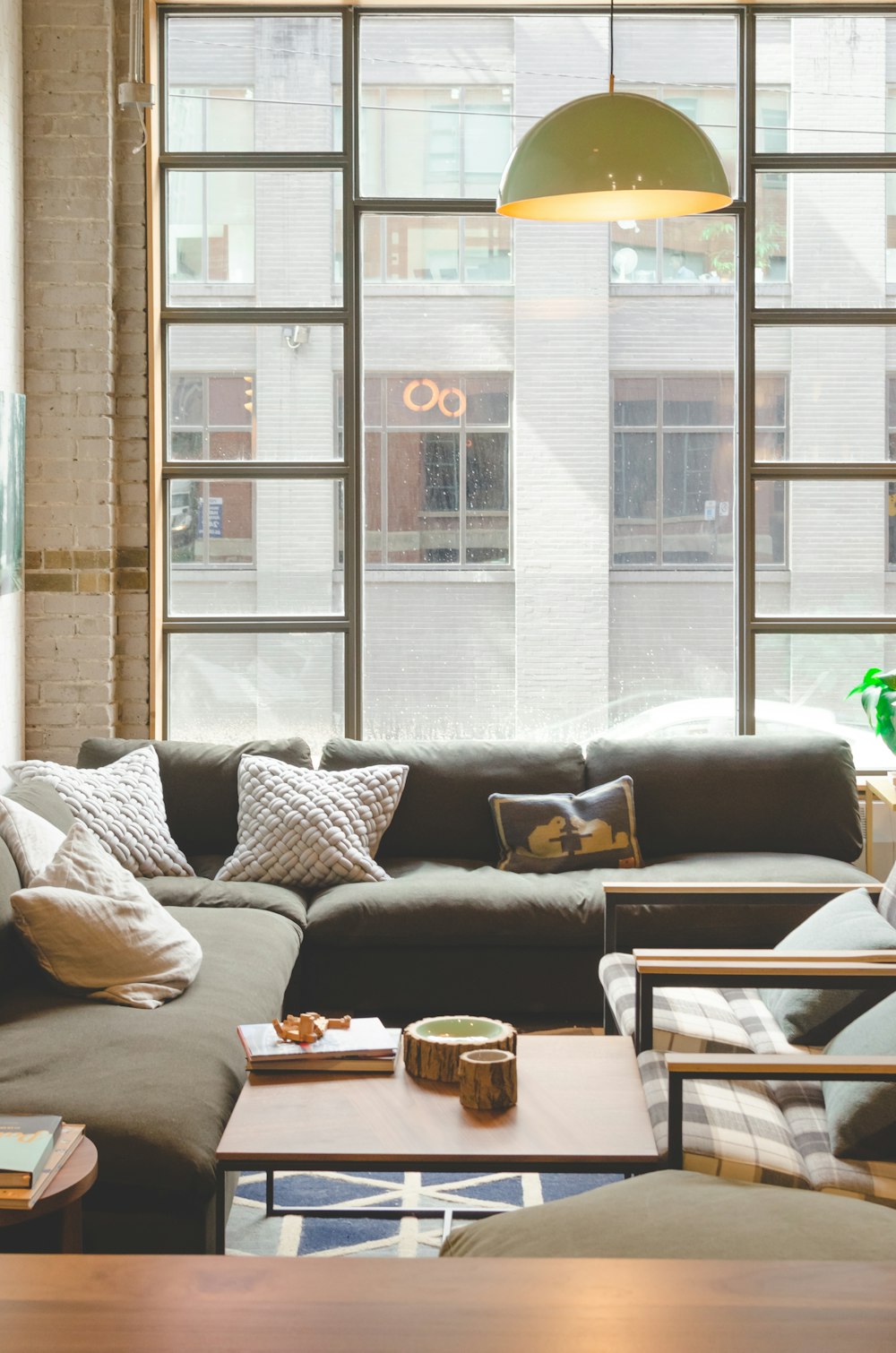 throw pillows on sectional sofa inside building with pendant lamp turned on