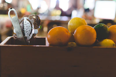 Close-up of a sachet cocktail kit with tropical fruits in the background, evoking summer celebrations.
