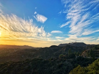 A scenic view from the deck overlooking rolling hills under a vibrant sunset sky.