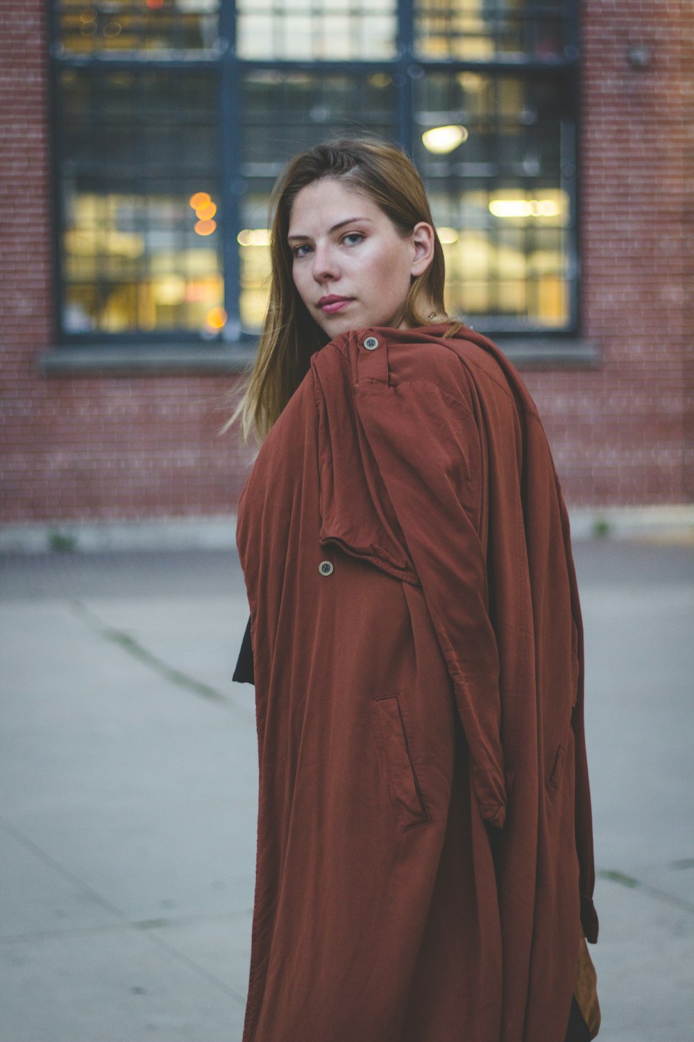 woman standing and holding red coat