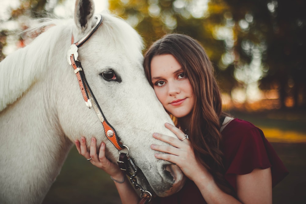 woman touching white horse