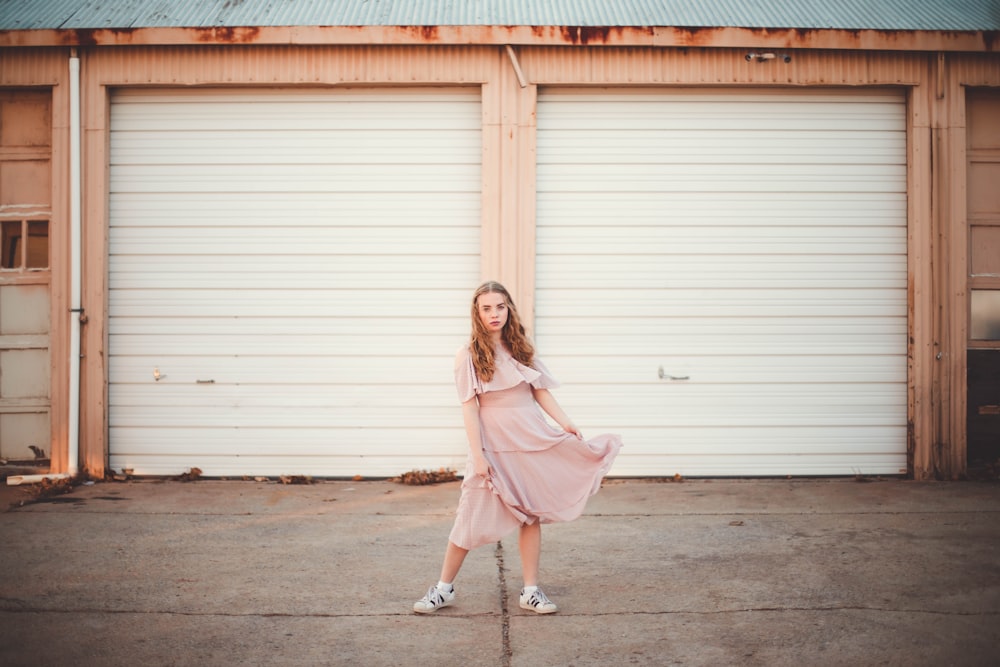 woman wearing dress standing in front of garage doors