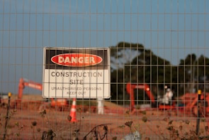 Close-up of a 'Site Under Construction' sign with tools in the background.