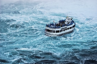 grey ferry sailing on blue turbulent waters