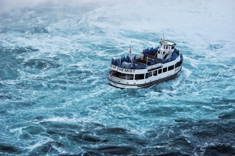 balsa cinza navegando em águas turbulentas azuis