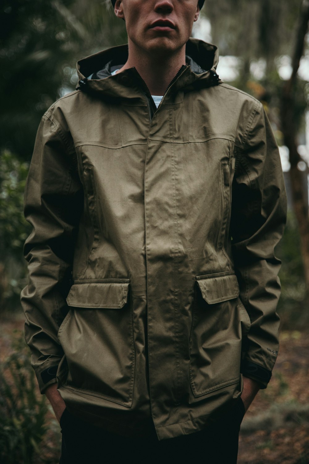 Foto de enfoque superficial de hombre con sudadera con capucha marrón con cremallera completa