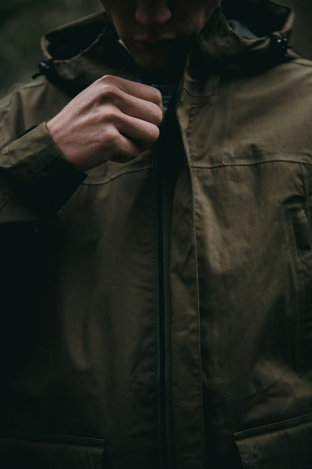 person zipping up brown hoodie