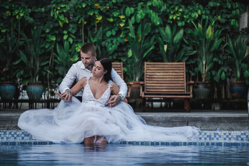 man in white suit behind woman in white dress