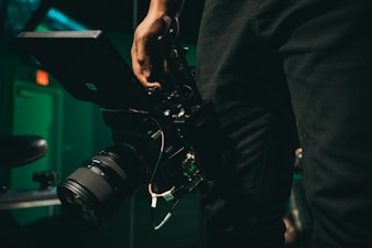 person holding black DSLR camera