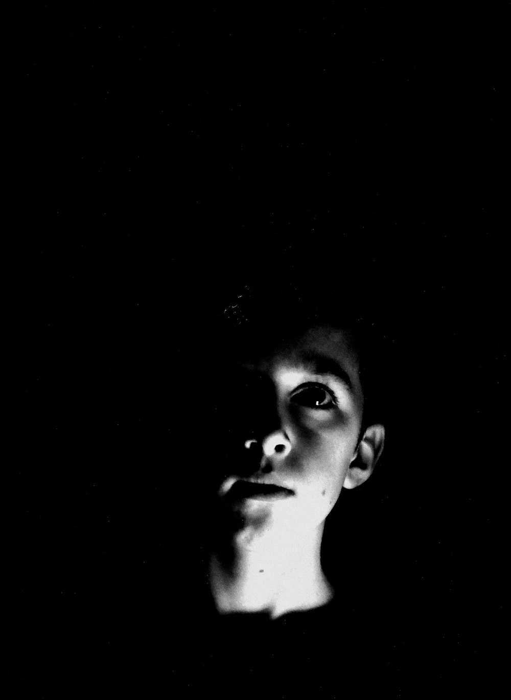 a black and white photo of a person in the dark