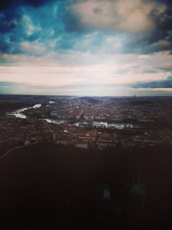 A moody, dark-overlayed panoramic view of Neuquén city skyline at dusk.