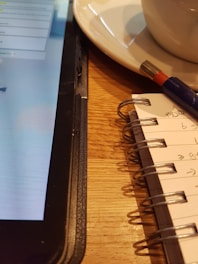 Team collaboration tracker template on a tablet with notes and pens nearby.