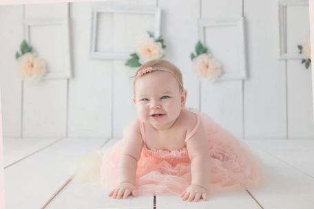 A smiling parent and baby engaging in a crawling workshop with vibrant decorations.