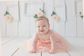 A smiling parent and baby engaging in a crawling workshop with vibrant decorations.