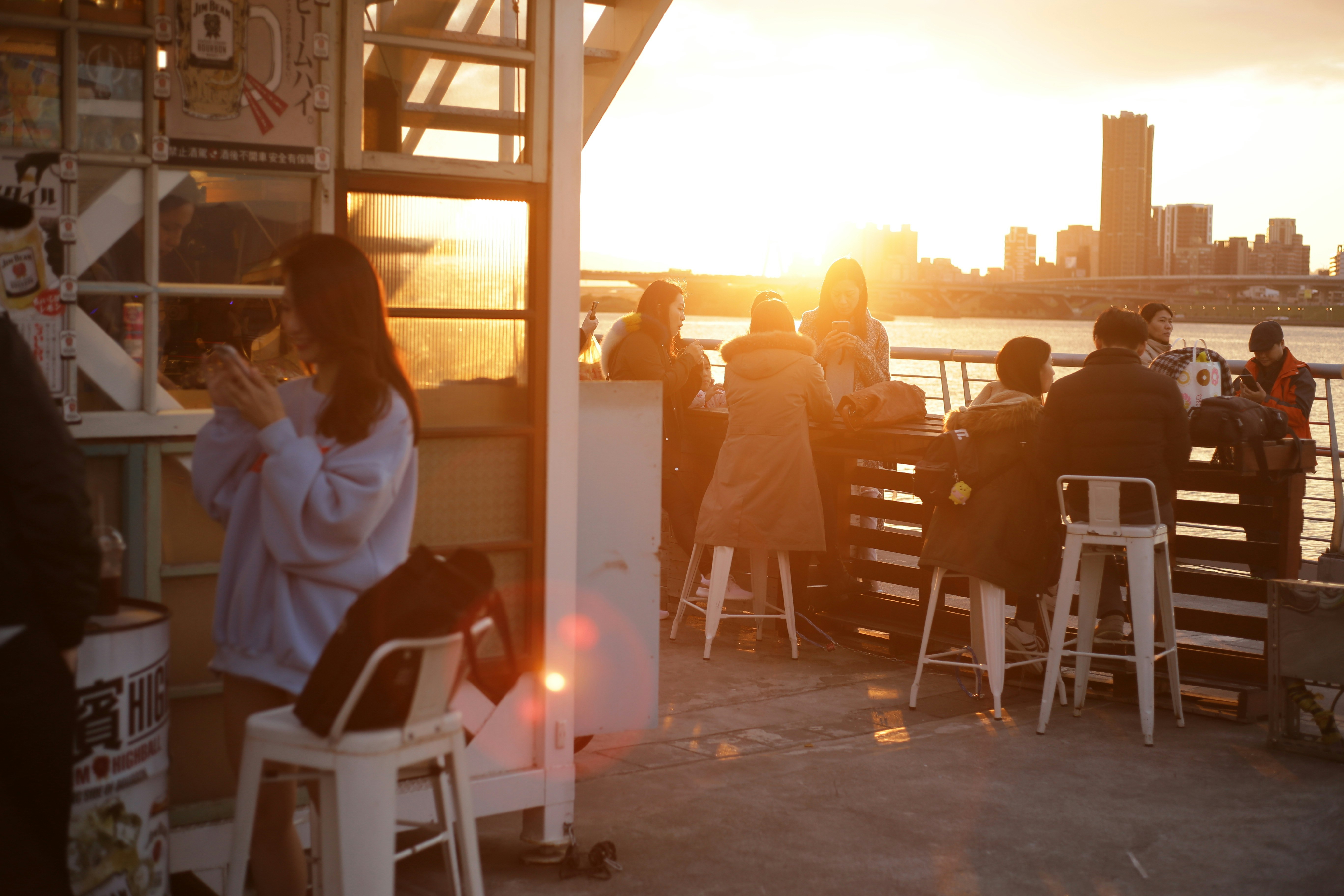 rooftop bar patrons toasting with city skyline at sunset - bars downtown chicago