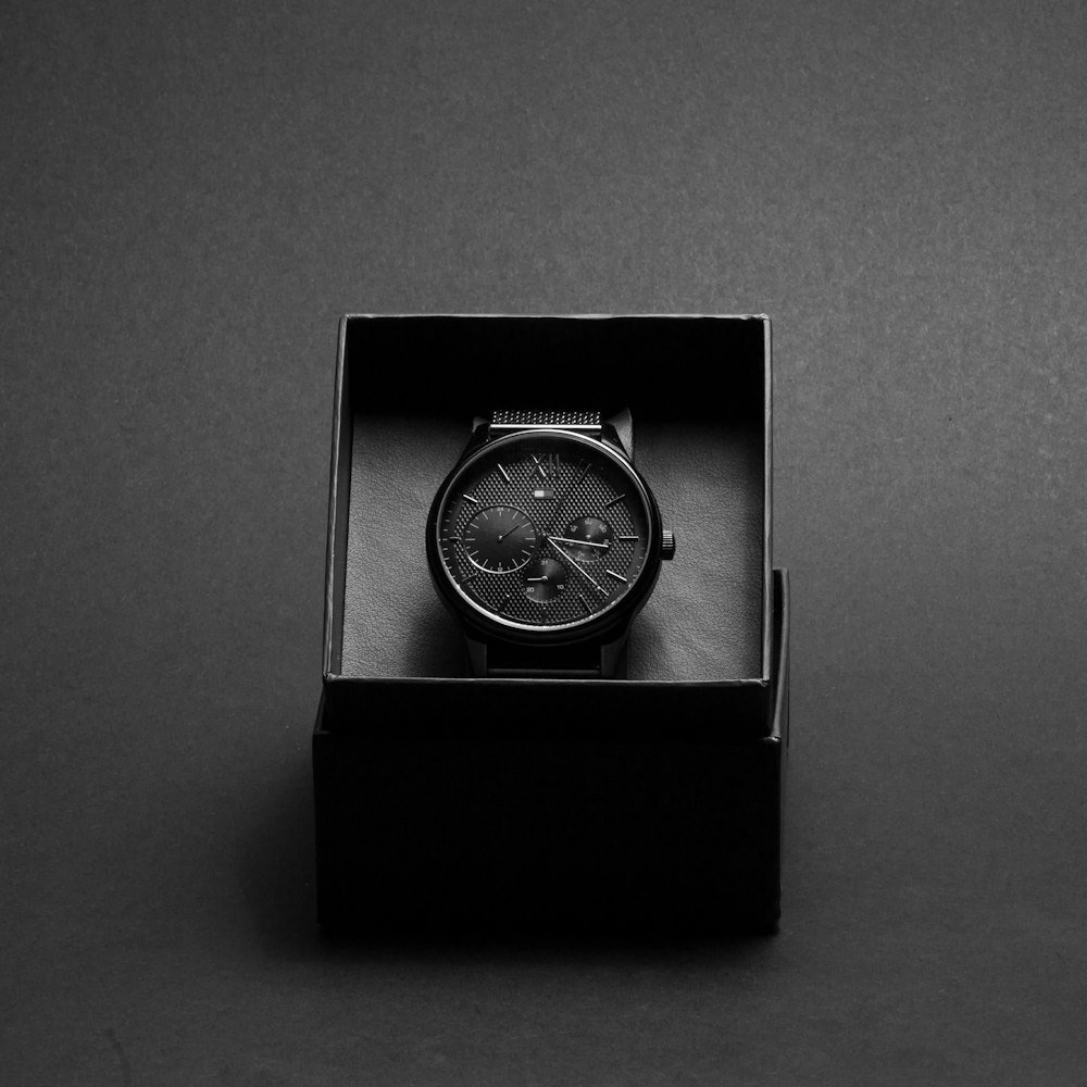 round black chronograph watch in case