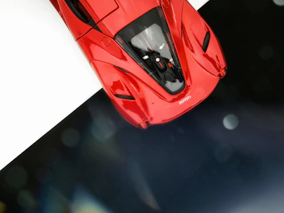 Sleek red Ferrari sports car angled to showcase its aerodynamic design.