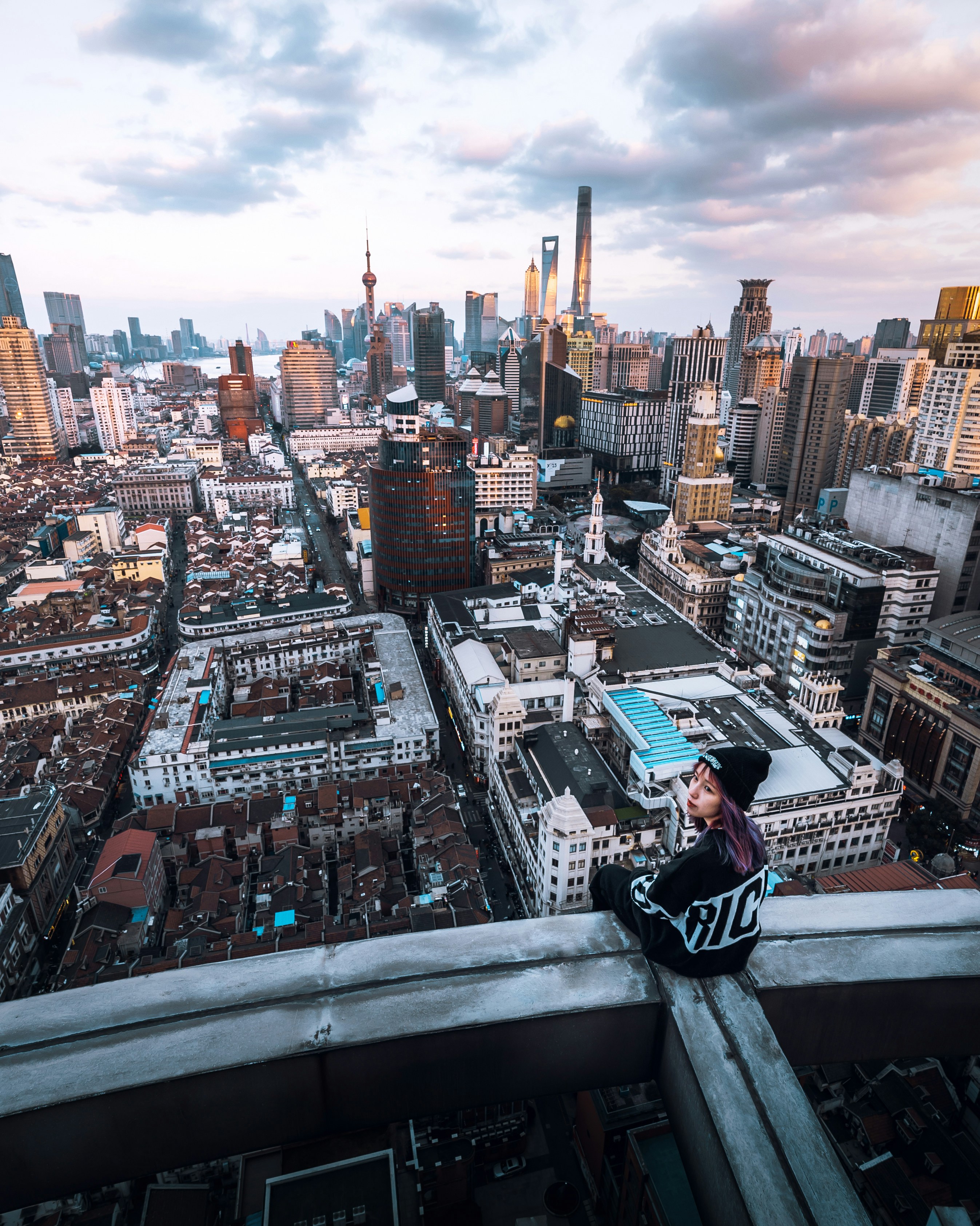 Woman Sitting On Rooftop Looking Backward Overlooking City Photo Free Landscape Image On Unsplash