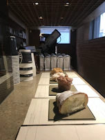 Assorted pastries displayed beside a freshly poured cup of coffee on a clean white counter.