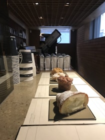 Fresh pastries and coffee cups displayed on a minimalist mobile café counter.