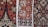Intricate textile patterns featuring geometric and symmetrical designs in rich colors, showcasing detailed motifs common in traditional fabric. The repeating shapes and lines are crafted with precision, creating a visually captivating and culturally significant piece.