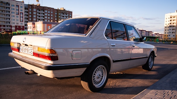 A sleek silver sedan parked on a sunlit city street, showcasing its polished finish.