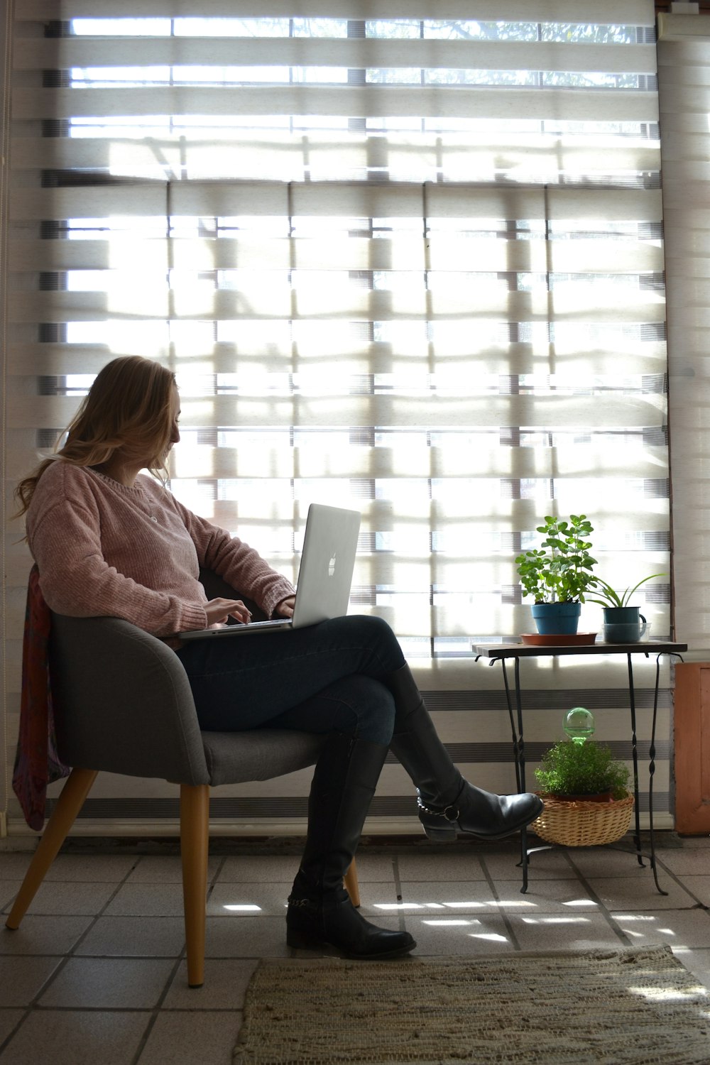 woman sitting on chair near window