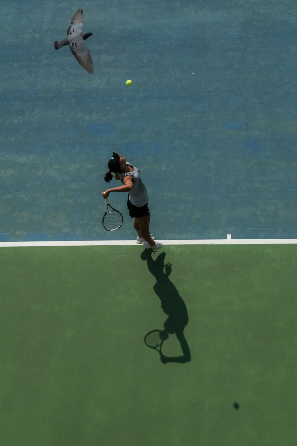 femme sur le point de casser une balle de tennis pendant la journée