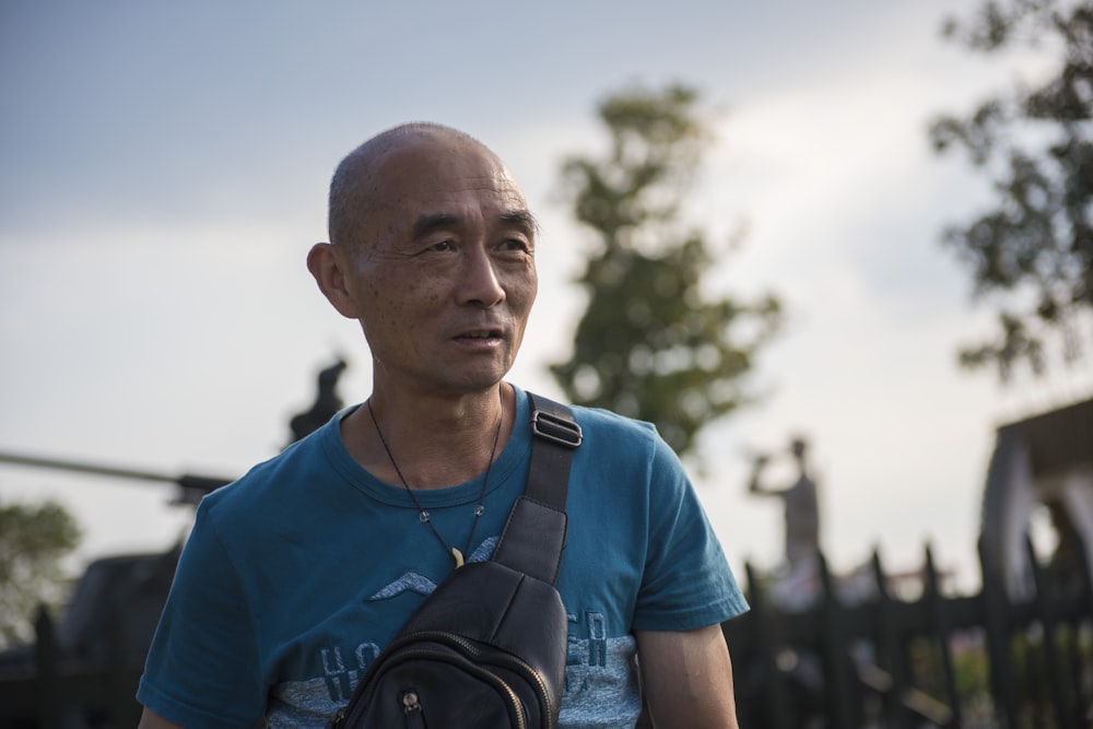 man in green t-shirt near fence on selective focus photography